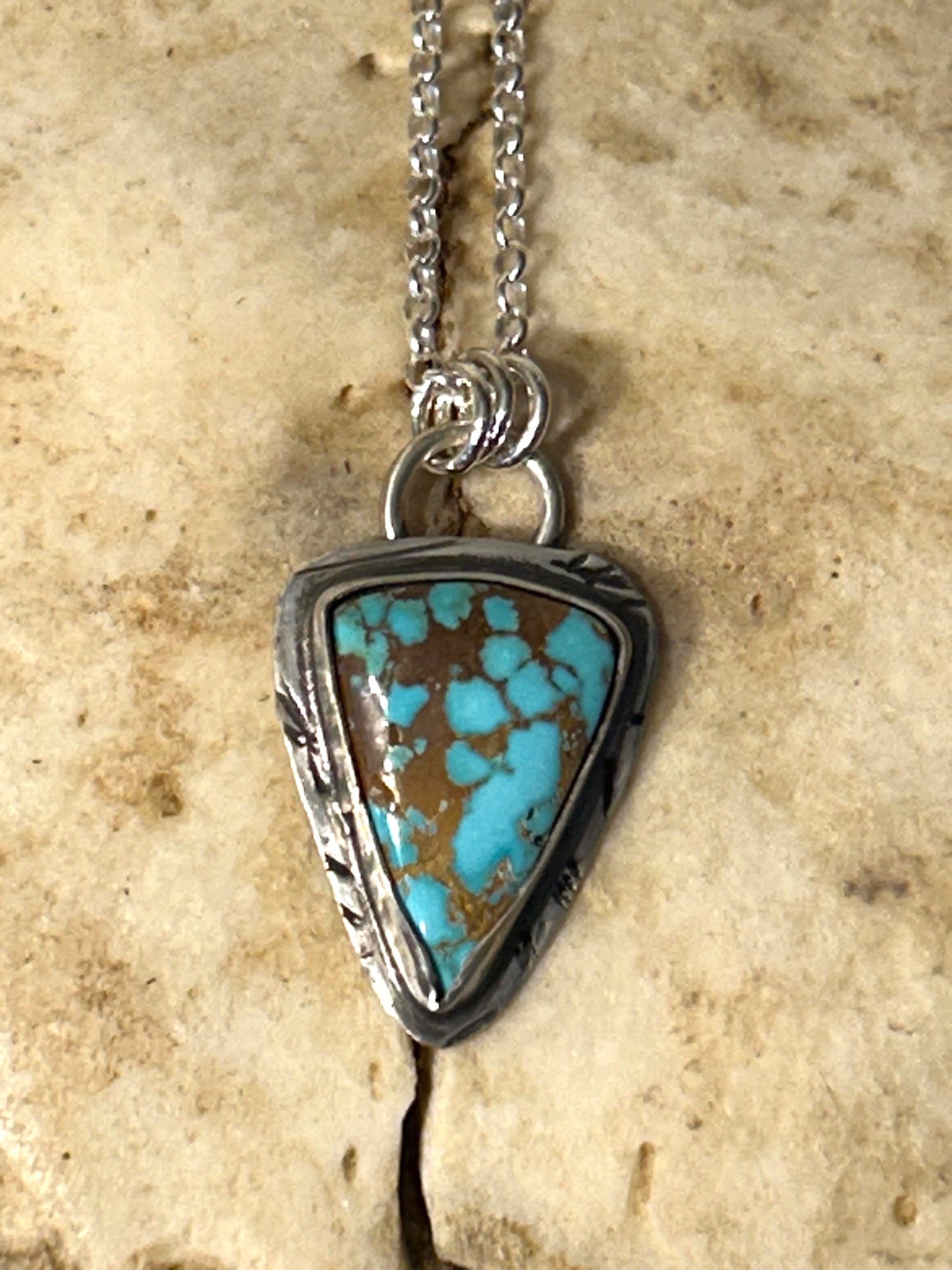 Triangle shaped blue Royston turquoise set in a rustic tuff gurlz sterling silver setting on an 18 inch sterling chain.