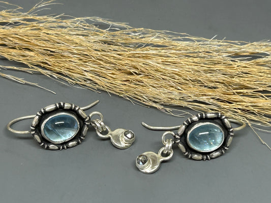Oval aquamarine stones set in sterling silver trimmed with silver accent wire and accented with genuine black diamonds.