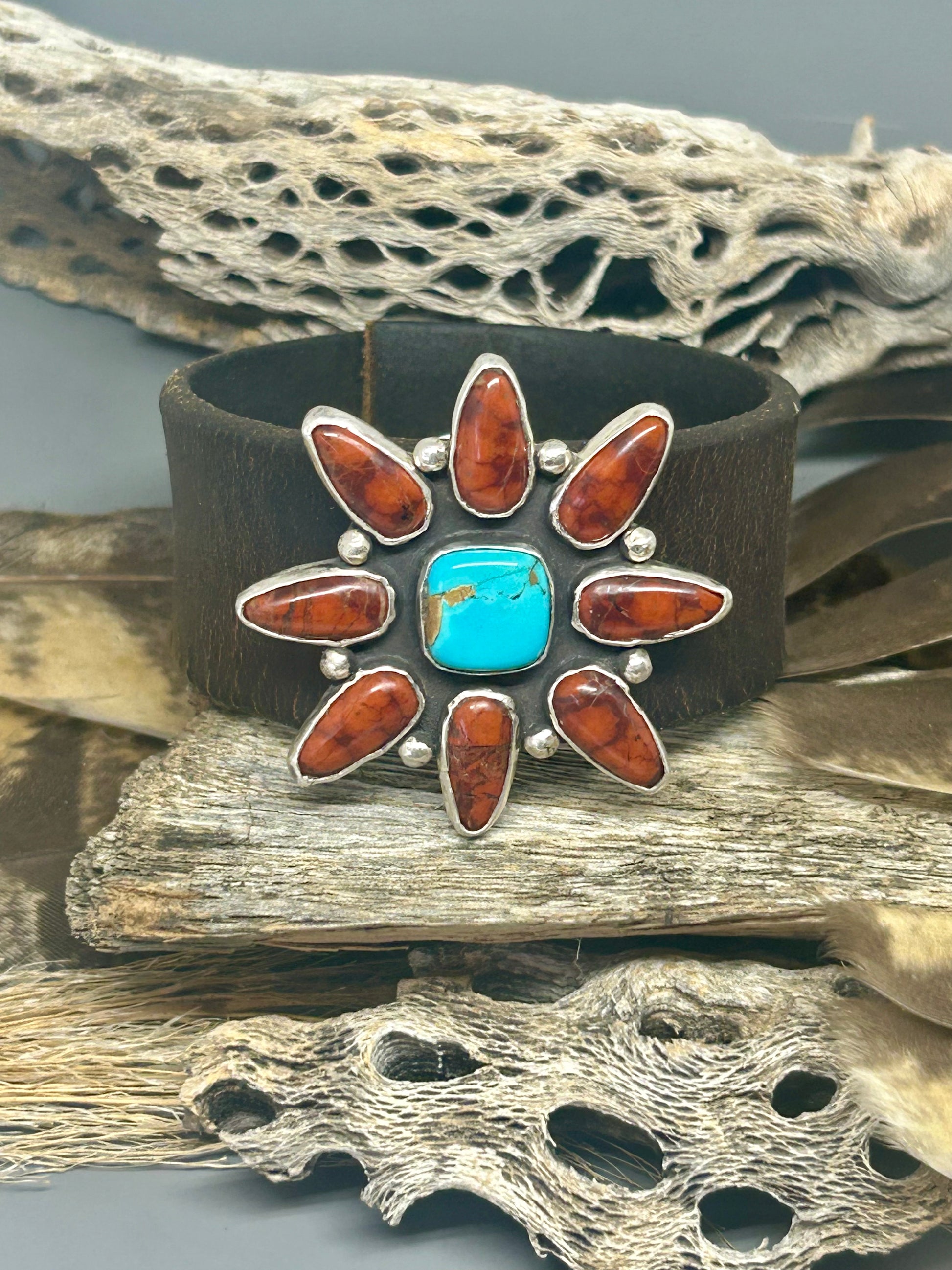 Bloody basin Jasper and Kingman turquoise set in sterling silver. This cluster sits a top 8 inches of repurposed horse rein leather.