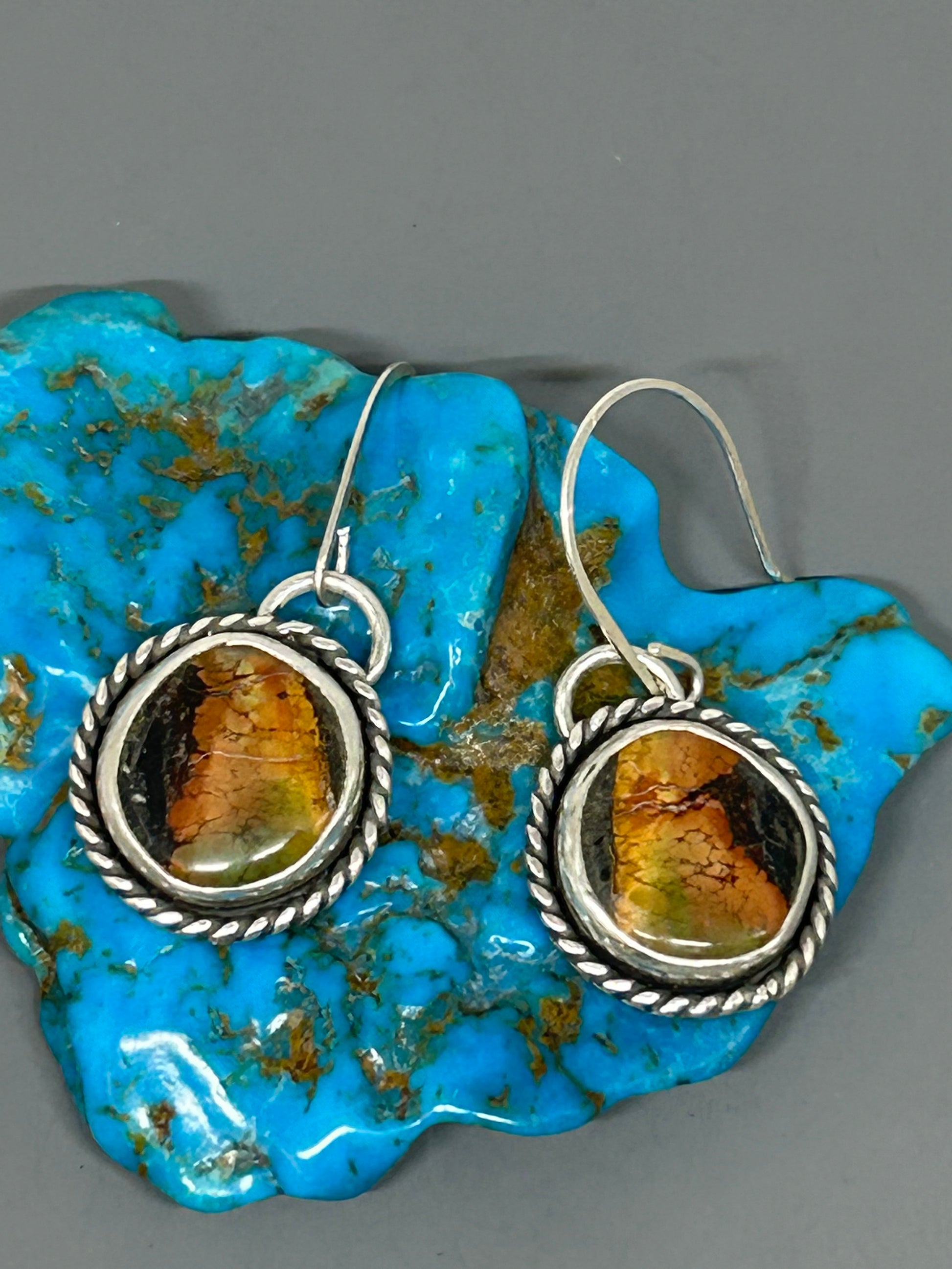 Round blackjack turquoise set in sterling silver, accented with silver with wire and a soft patina. 