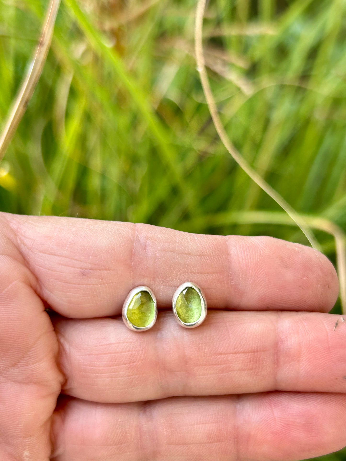 Green peridot gemstones set in sterling silver with silver posts and ear backs.