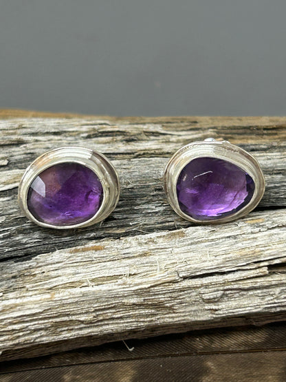 Rose cut purple asymmetrical amethyst stones set in sterling silver with a shiny finish. Silver ear posts and backs.