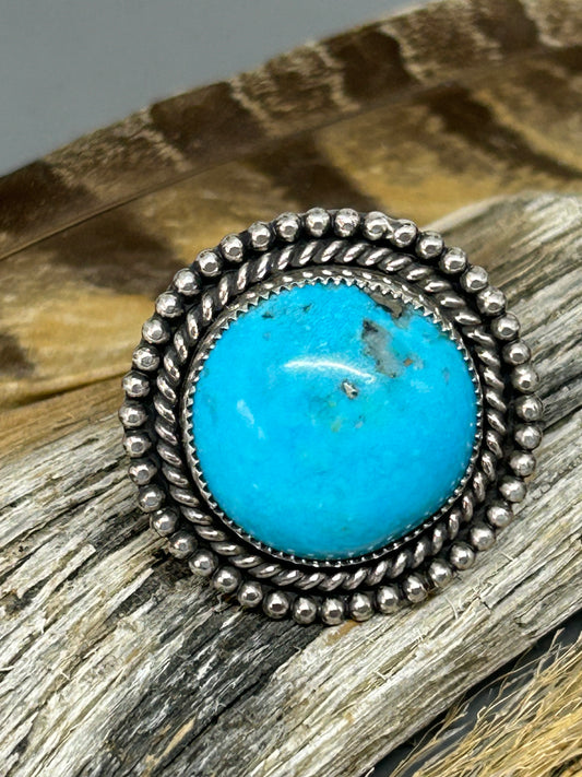 Round Persian turquoise set in sterling silver accented with sterling twist and bead wire with an adjustable band.