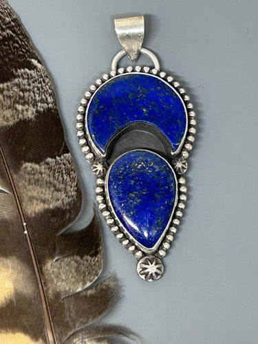 Two pieces of lapis with pyrite flecks set in sterling silver accented with silver concho stars and bead wire.
