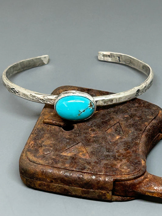 Oval blue Royston turquoise set in a rustic sterling setting on a 6 inch adjustable band.