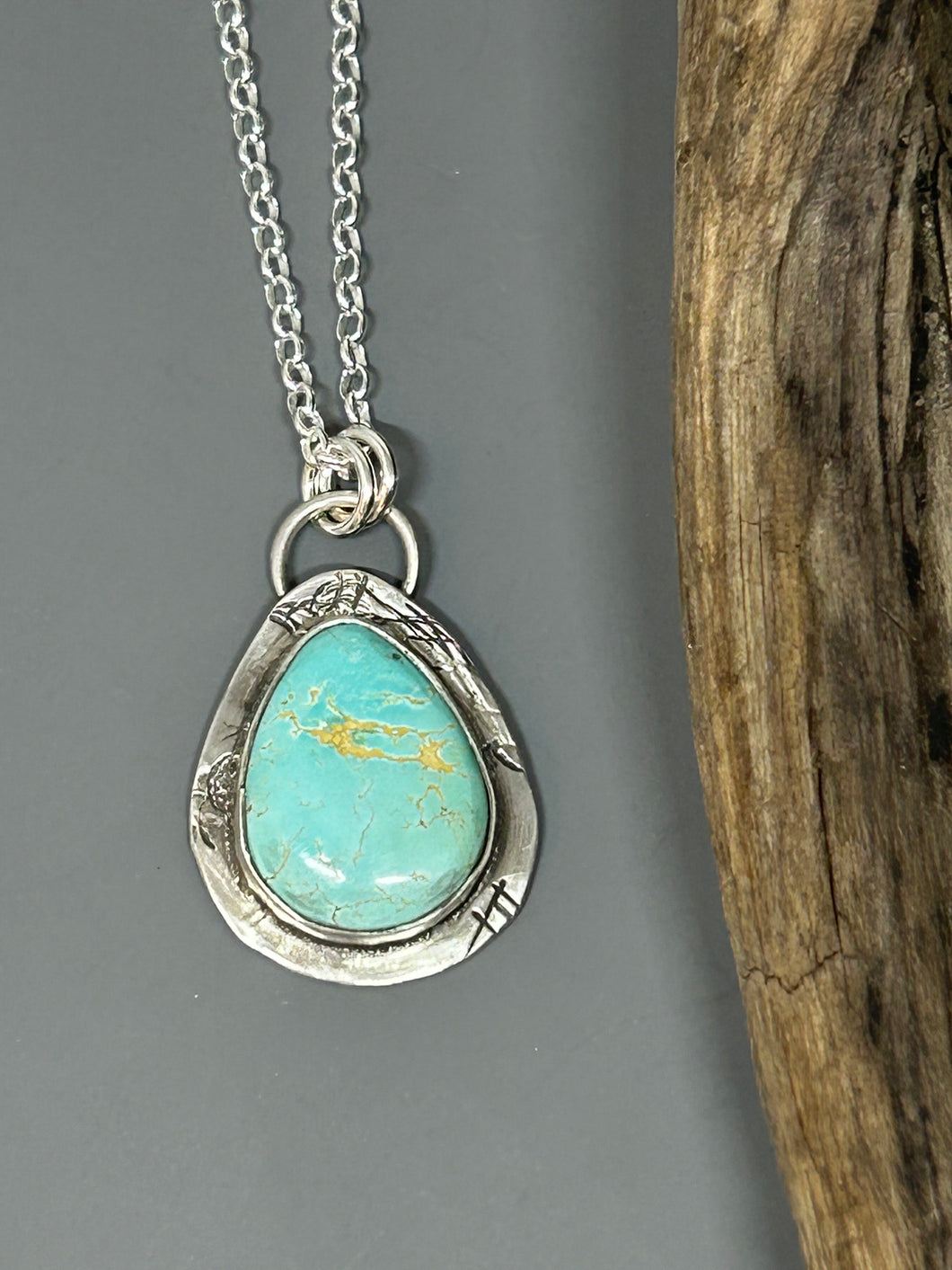 Light blue colored natural royston turquoise set in a rustic sterling silver setting with a soft patina.