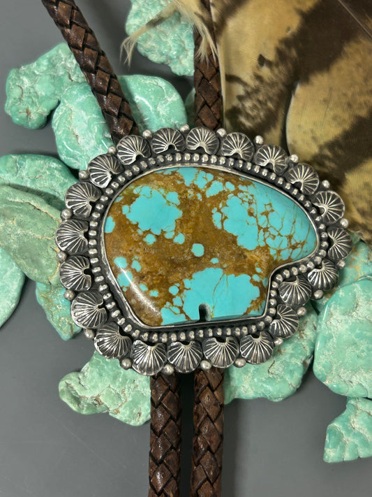 mine number 8 bear shaped turquoise. Set in sterling silver accented with sterling bead wire, hand stamped embellishments and balls. sterling silver caps with silver flowers on the leather bolo tips.
