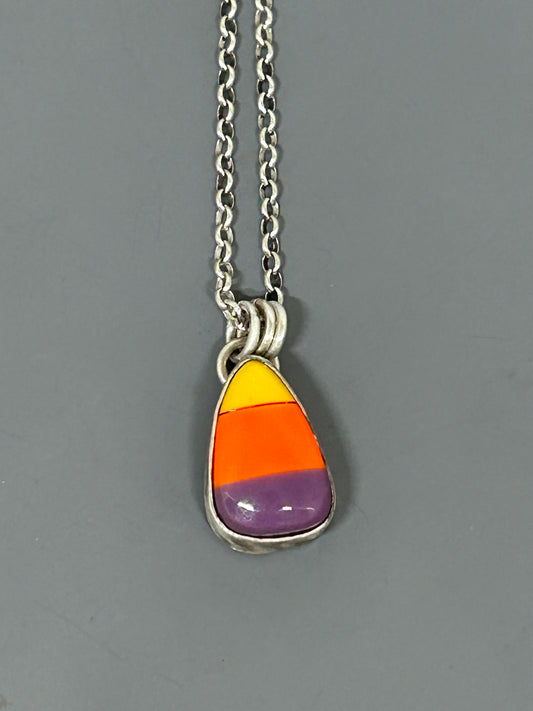 Candy Corn cabochon colored yellow orange and purple, set in sterling silver with a soft patina. This pendant hangs on an 18 inch sterling silver chain.