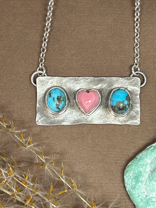 Kingman turquoise and pink conch shell heart set in a sterling silver bar necklace design on an 18 inch sterling silver chain.