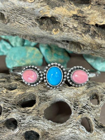 This pink conch shell and Kingman turquoise sterling silver cuff is a reminder to stay grounded during transition. Size inches long and adjustable.