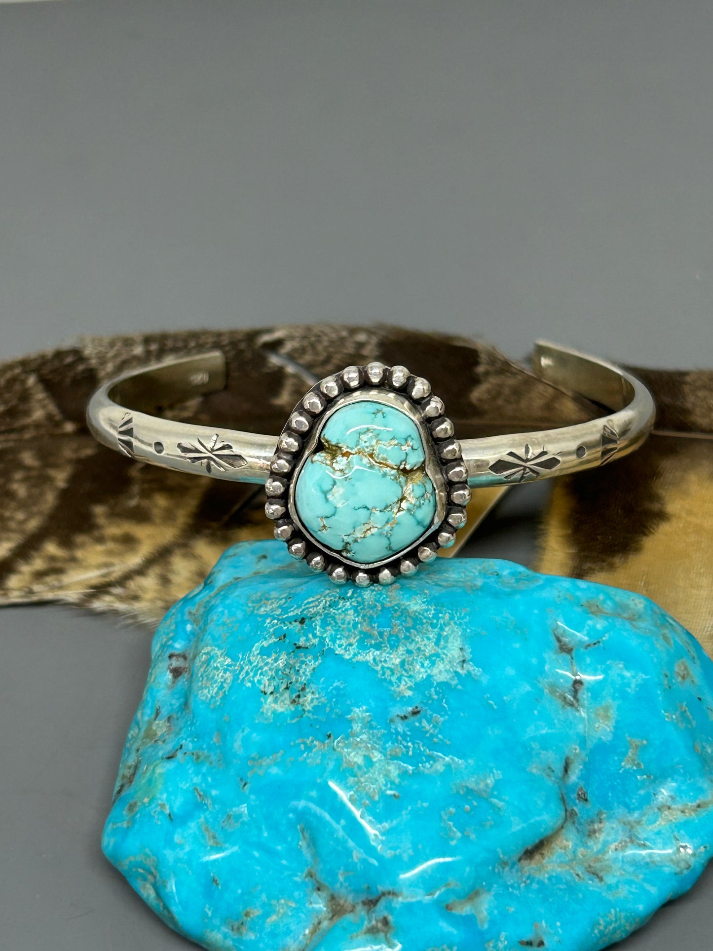 Godber turquoise set in sterling silver accented with bead wire and hand stamping with a soft patina. This 4 gauge cuff bracelet is 6 inches long and adjustable.