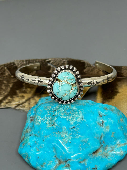 Godber turquoise set in sterling silver accented with bead wire and hand stamping with a soft patina. This 4 gauge cuff bracelet is 6 inches long and adjustable.