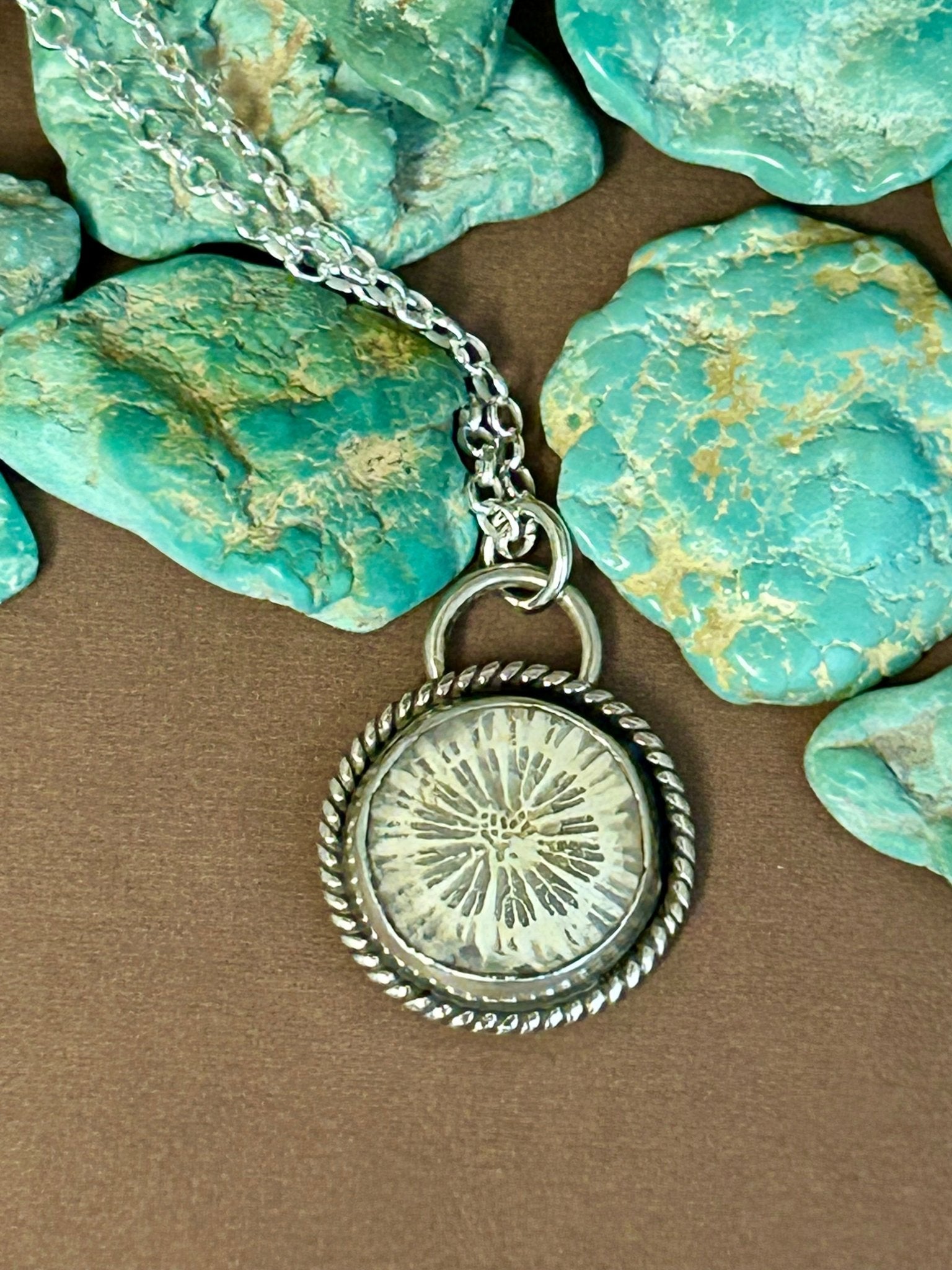 This coral fossil cabochon is set in a simple sterling silver setting accented with thin silver twist accent wire on an18 inch sterling silver chain.