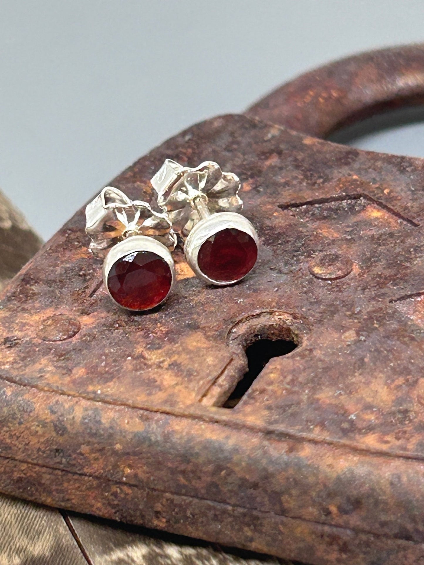 Round garnet rose cut gemstones 5 mm in diameter set in sterling silver with silver posts and ear nuts.