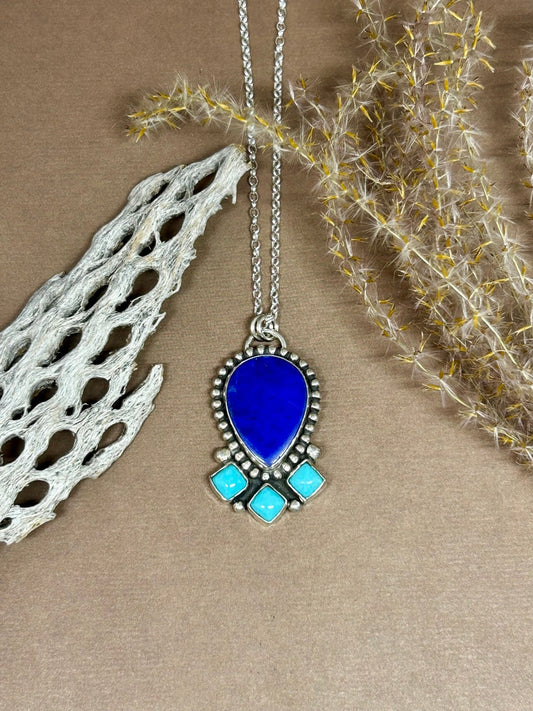 This lapis and persian turquoise necklace represents protection, strength, clarity and grounding. This pendant hangs on an 18 inch sterling silver chain.