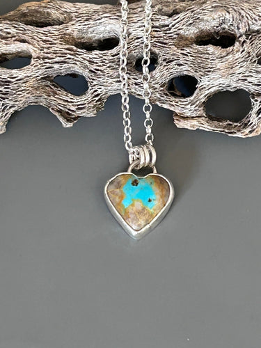 Royston heart shaped turquoise stone set in sterling silver. It hangs on an 18 inch sterling silver chain.