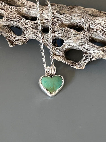 Kingman heart shaped turquoise set in sterling silver. It hangs on an 18 inch sterling silver chain.