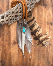 Load image into Gallery viewer, Naturally shed deer antler set in sterling silver accented with two Moronic turquoise stones.  This pendant hangs on 38 inches of soft brown leather.
