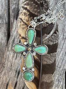 Tyrone turquoise in a cross setting made of sterling silver,  It hangs on an 18 inch sterling silver chain.  Handmade by Taylor Made Silver.