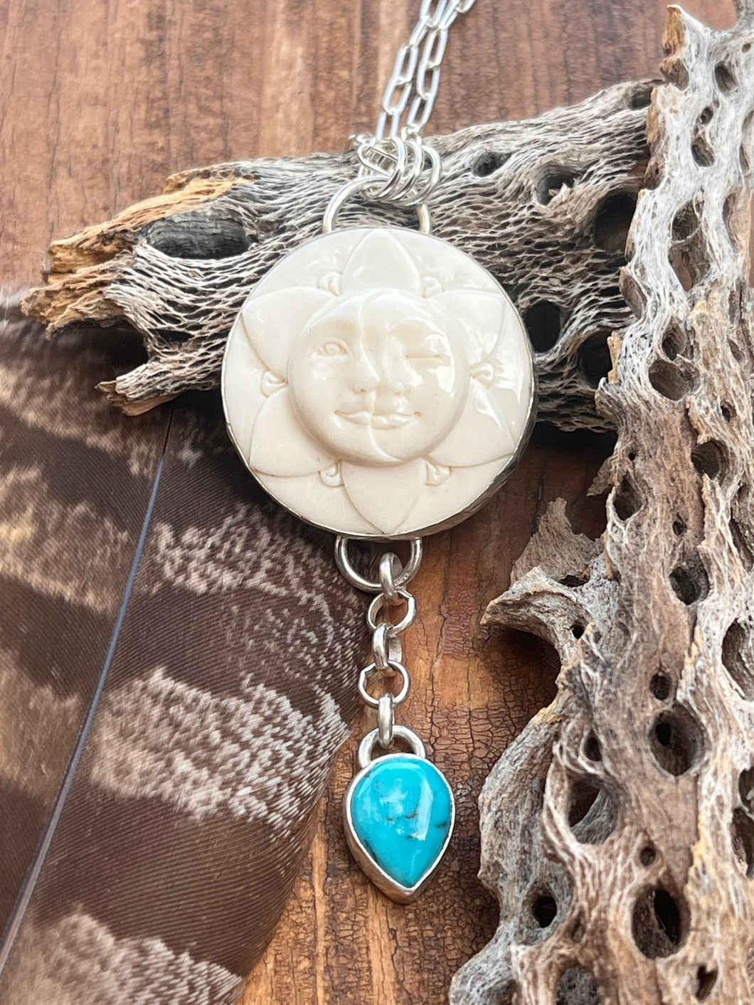 Sun and moon carved bone cabochon set in sterling silver accented with thunder Mountain turquoise.  This celestial pendant hangs on a 18 inch sterling silver chain, handmade by Taylor Made Silver.